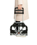 Person holding a ✝️ Folding Hand Truck Aluminum Portable Folding Hand Cart 165lbs Capacity Hand Cart and Dolly Ideal for Home, Auto, Office, Travel Use, Black, folded and compact