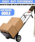 Person using ✝️ Folding Hand Truck Dolly - 600 LB Capacity with boxes, showcasing heavy-duty wheels in warehouse setting.