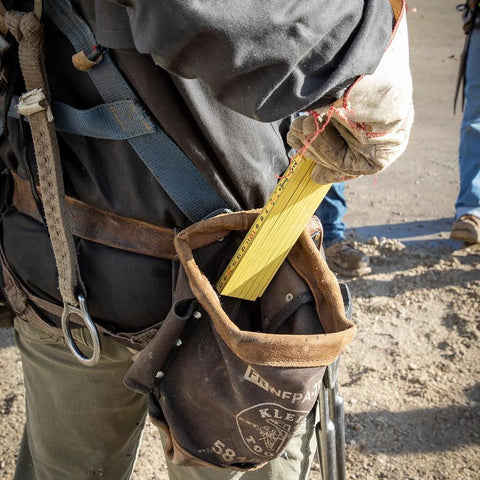 Worker using Folding Ruler 6-Foot Fiberglass With Brick Scale On Reverse And Outside Reading One Sixteenth Inch Graduation Riveted Lock Joints in field.
