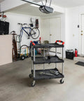 Portable Folding Tool Service Cart On The Go With 150 Lb Capacity, Locking Mechanism, Three Shelf Ergonomic Design, Black Red Finish For Tools And Maintenance, Olympia Tools in a garage setting