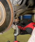 Mechanic using 26554 Front End Service Kit, Pitman Arm Puller & Ball Joint Separator on vehicle suspension