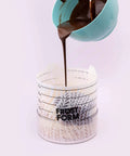 Pouring chocolate into 6 Inch Frost Form Starter Kit For Cake Decorating 7 Piece Set With Liner Form Base Stand Crumb Cutter Finisher