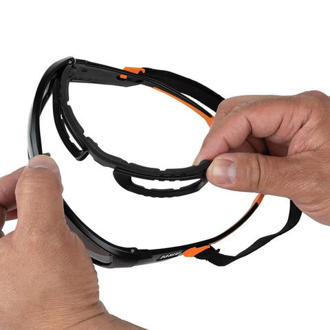 Hands holding Full Frame Gasket Safety Glasses With Foam Seal Anti Fog UV Scratch Resistant, showing detachable foam gasket.