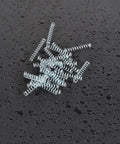 Pack Of 100 Heavy Duty Galvanized Steel Wire Compression Springs For Ballpoint Pens on wet surface, 0.4mm wire, 4mm OD, 25mm length
