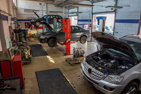 Outdoor Rubber Floor Mat With Drainage Holes Anti Slip Heavy Duty Entrance Mat in a garage with cars on lifts