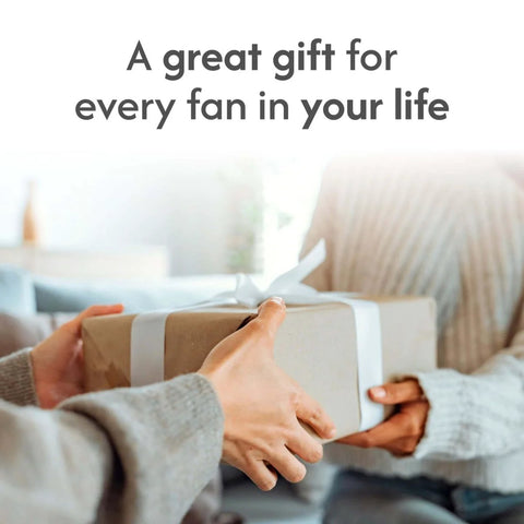 Hands exchanging a gift box with text "A great gift for every fan in your life" in cozy room setting
