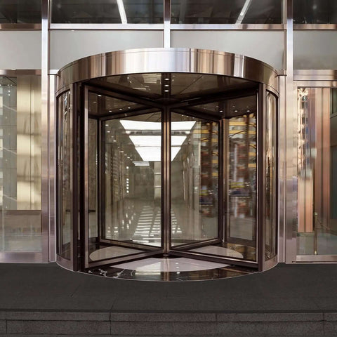 Stainless steel revolving glass door at entrance of modern building