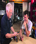 Two people using the GM TPMS Relearn Tool for 2006-2024 Chevy Buick GMC Opel Cadillac Vehicles 315/433 MHz in a garage setting