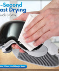 Front view of hand cleaning a reflective helmet visor with a pre-moistened eyeglass lens wipe