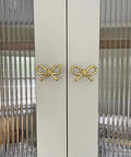 2 Pack Solid Brass Bow Drawer Knobs In Gold on cabinet doors showcasing elegant bow style
