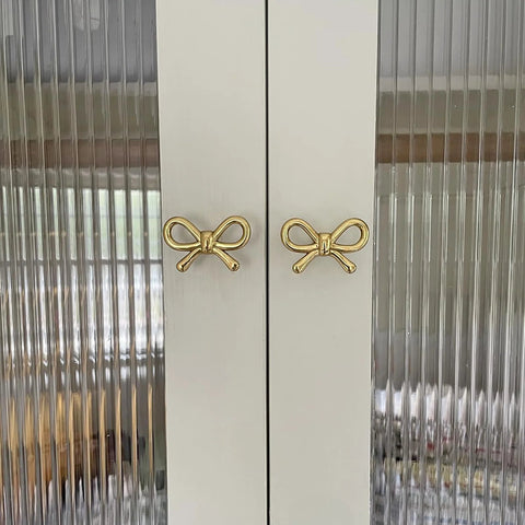 2 Pack Solid Brass Bow Drawer Knobs In Gold on cabinet doors showcasing elegant bow style