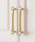 Gold Crystal Drawer Pulls 4 Pack 3-3/4 Inch Hole Center 5 Inch Elegant Dresser Cabinet Pulls with teardrop crystals on a cupboard.