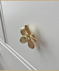 Side view of a Six Pack 2.4 Inch Gold Flower Cabinet Knob on a dresser, featuring a vintage floral petal pull design in elegant gold finish.