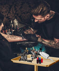 Premium Aluminum Salon Tray With Adjustable Height From 26 To 43 Inches On Wheels, Corrosion Resistant Mobile Tool Tray For Beauty Spa And Dental Clinics, Gold Finish With Four 360 Degree Rotating Casters in use at tattoo studio