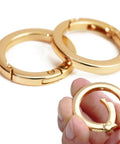 2 Pack 1 Inch Spring O Rings For Purses And Handbags, Gold Finish, shown with easy spring opening mechanism in hand