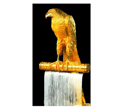 Gold sculpture of a falcon on a textured pedestal, showcasing a metallic finish and intricate details