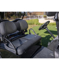 Black four-seat golf cart with steering wheel on a grassy background