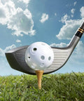 Golf club hitting a white practice ball on a tee in grass, part of the 50 Pack Colored Golf Practice Ball, 40mm Hollow Sports Golf Training Balls Plastic Airflow Good for Your Pets(Multicolor) set.