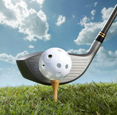 Golf club hitting a white practice ball on a tee in grass, part of the 50 Pack Colored Golf Practice Ball, 40mm Hollow Sports Golf Training Balls Plastic Airflow Good for Your Pets(Multicolor) set.