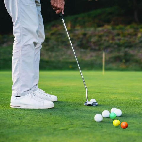 Person practicing putting on a golf course with Practice Golf Balls - 24 Pack Colored Plastic Balls 41mm Training Realistic Feel Limited Flight