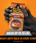 Tough As Nails Industrial Strength Heavy Duty Double Sided Mounting Tape Weatherproof 1 Inch By 60 Inch Black Pack Of 2 Ideal For Indoor Or Outdoor Use That Mounts Up To 30 Pounds For Hanging Clocks Frames Mirrors Shelves And More packaging held by gorilla hand