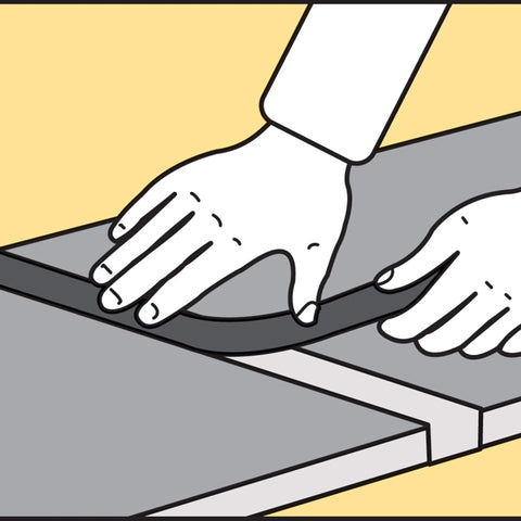 Hand inserting Versatile Gray Foam Backer Rod Set 1/2in x 20ft - Essential Caulk Saver between concrete slabs, sealing gaps.