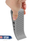 Hand holding gray door stopper with honeycomb design, Door Stoppers for Bottom of Door Premium Floor Rubber Door Stop Wedge Made in USA