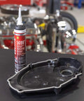 RTV High Performance Silicone Sealant Gray 190 Ml For Flexible Gaskets And High Torque Applications With Heavy Duty Performance And Superior Oil Resistance Low Odor Noncorrosive Formula next to an engine cover