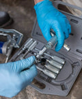 Person assembling Versatile Grease Lubrication Adapter Kit with 12 Inch Hose and Quick Connect Couplings in case