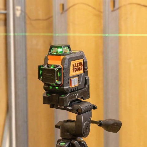 Side view of a compact self-leveling laser level with bright green cross lines and 360-degree planes delivering precise alignment on tripod.