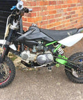 Rear Shock For Dirty Pit Bike With Adjustable Rebound And Dual Spring Options 250lb Or 350lb mounted on black and green bike