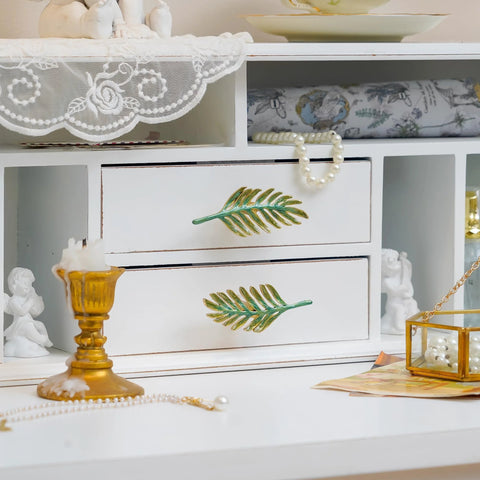 Set Of 2 Metal Green Leaf Cabinet Pulls And Drawer Handles With Simulated Leaf Shape Gradient Color And Glossy Finish, installed on white drawers.