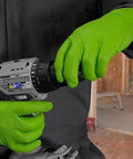 Close-up of hands wearing Green Nitrile Latex Free Gloves 8 Mil Heavy Duty Raised Diamond Texture Box 100, gripping a power drill.