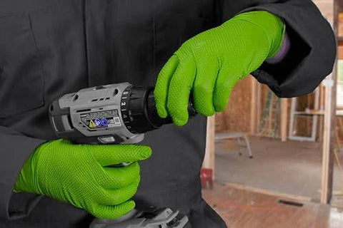 Close-up of hands wearing Green Nitrile Latex Free Gloves 8 Mil Heavy Duty Raised Diamond Texture Box 100, gripping a power drill.