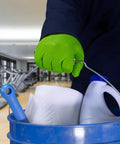 Person wearing Green Nitrile Latex Free Gloves 8 Mil Heavy Duty Raised Diamond Texture holding cleaning supplies bucket in gym