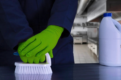 Person wearing Green Nitrile Latex Free Gloves 8 Mil Heavy Duty Raised Diamond Texture Box 100 cleaning with brush in kitchen