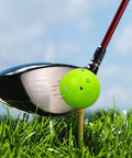 Golf club hitting green plastic practice golf ball on tee, part of 50 Pack Plastic Golf Balls Practice Limited Flight Golf Training Ball Hollow Swing Practice Indoor Balls with Mesh Drawstring Bag for Backyard Driving Range or Outdoor (Green).