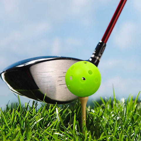 Golf club hitting green plastic practice golf ball on tee, part of 50 Pack Plastic Golf Balls Practice Limited Flight Golf Training Ball Hollow Swing Practice Indoor Balls with Mesh Drawstring Bag for Backyard Driving Range or Outdoor (Green).