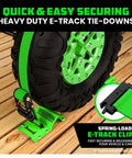 Heavy Duty Wheel Chock Tie Down Kit With 4500 Pound Break Strength Includes 2 Wheel Chocks And 4 Ratchet Straps For E Track System For ATV UTV Lawn Mower And Trailer Green Rhino USA showing green wheel chock securing a tire with ratchet strap on wooden surface