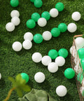 Green Ball Pit Balls - Crush Proof Plastic Balls for Ball Pit Pack of 100pcs Set for Toddlers scattered on grass with storage basket
