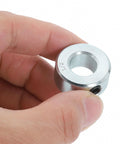Close-up of a zinc-plated carbon steel collar from Sixteen Piece Set Screw Shaft Collars For One Half Inch Bore And One Inch Outside Diameter Seven Sixteenth Inch Thick Zinc Plated Carbon Steel Locking Collars For Linear Rods And Shaft Guides held between fingers.