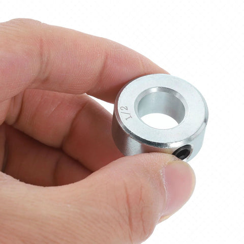 Close-up of a zinc-plated carbon steel collar from Sixteen Piece Set Screw Shaft Collars For One Half Inch Bore And One Inch Outside Diameter Seven Sixteenth Inch Thick Zinc Plated Carbon Steel Locking Collars For Linear Rods And Shaft Guides held between fingers.