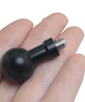 Close-up of a Two Pack 17mm Ball Head to Quarter Inch Stainless Steel Short Screw Connecting Rod held in hand, showing black aluminum and steel construction.
