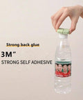 Hand holding a water bottle with a green cap and text '3M Strong Self Adhesive' displayed beside.