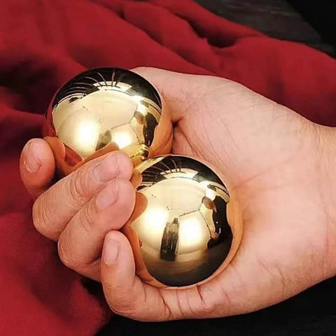 Hand holding 2Pcs Brass Exercise Ball 1.5 Inch Golden Solid Copper Metal Baoding Balls for Hand Therapy Stress Relief, Chinese Kung Fu Massage Acupressure Tool