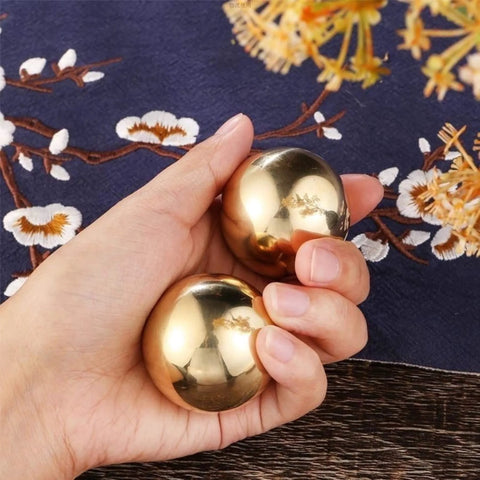 Hand holding Tianigo Copper Baoding Balls Set, 1.57 Inches Chinese Health Balls, Metal Stress Relief Hand Massage Balls No Chime for Hand Exercise