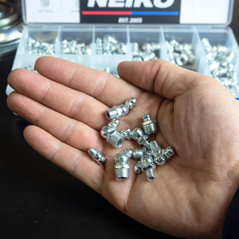 Hand holding zinc plated steel zerks from Grease Fittings Kit With 135-Piece Metric Zerk Assortment For M6-1, M8-1, M10-1.5 by NEIKO
