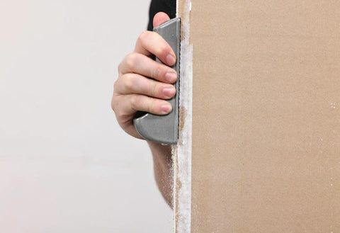 Hand using Pocket Drywall And Ceiling Tile Rasp With Replaceable Blade Designed For Fine Edge Trimming Of Drywall And Tiles