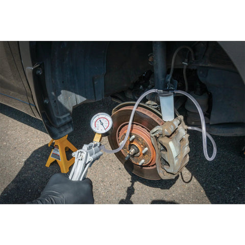 hand vacuum pump for brake bleeding in use on car brake system
