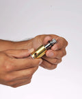 Person holding a small brass precision tool with a knurled adjustment knob.